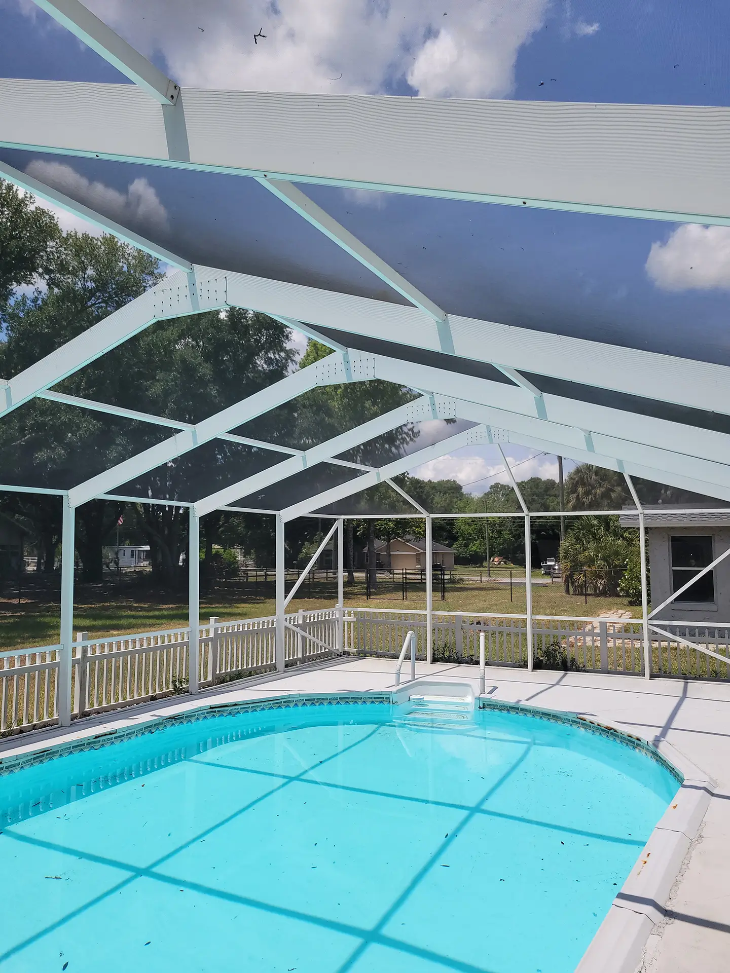 Sparkling clean pool and screened enclosure after thorough pressure washing service