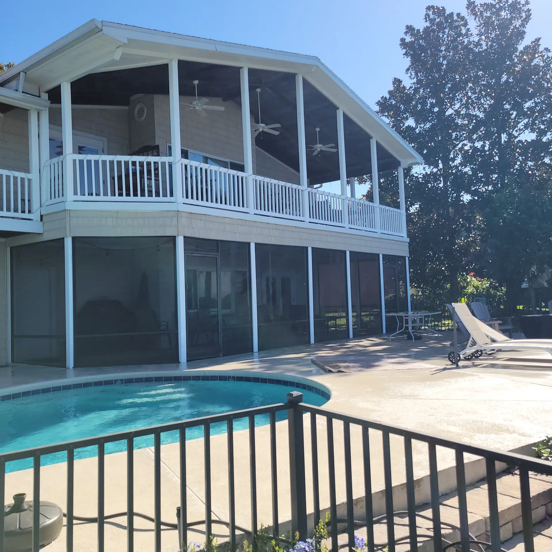 Vibrant pool and screened enclosure gleaming after expert pressure washing service